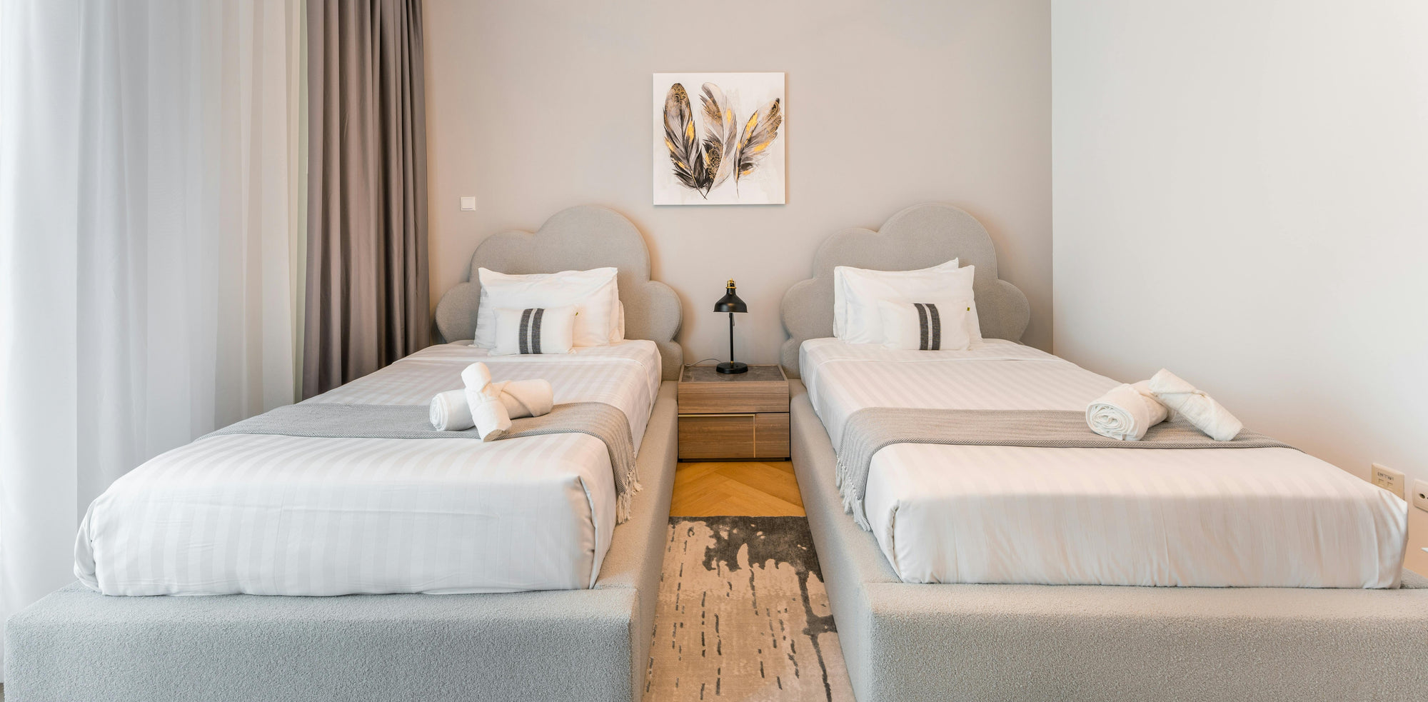 Two single beds in a modern bedroom with neutral decor.
